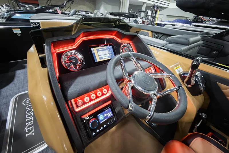 Slide: The Image of 2026 Godfrey Aquapatio 235 ULC Tritoon dashboard with illuminated controls and steering wheel. - 10
