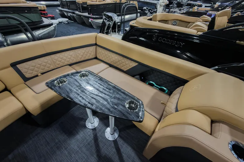 Slide: The Image of Luxurious seating on 2026 Godfrey Aquapatio 235 ULC Tritoon with elegant table and cup holders. - 18