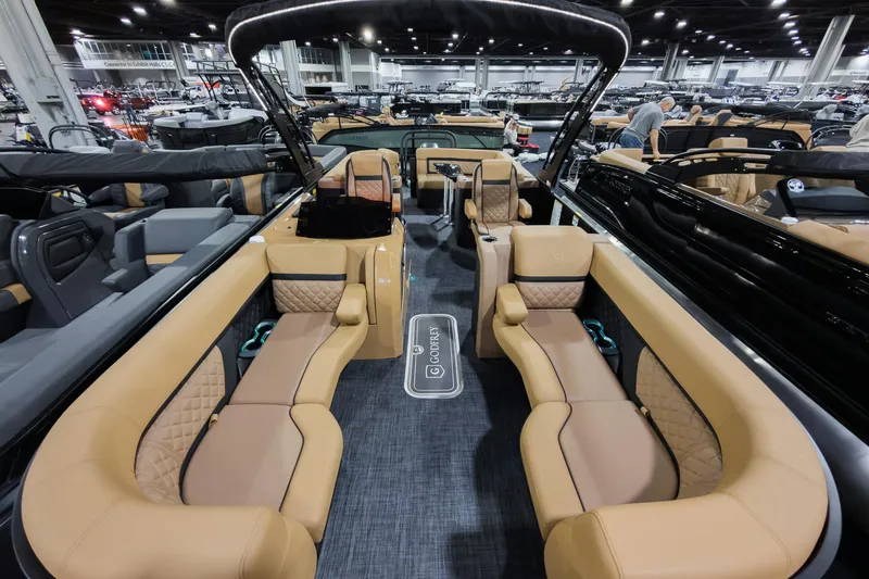 Slide: The Image of Luxurious interior of 2026 Godfrey Aquapatio Ultra Lounge Tritoon boat at a showroom. - 2