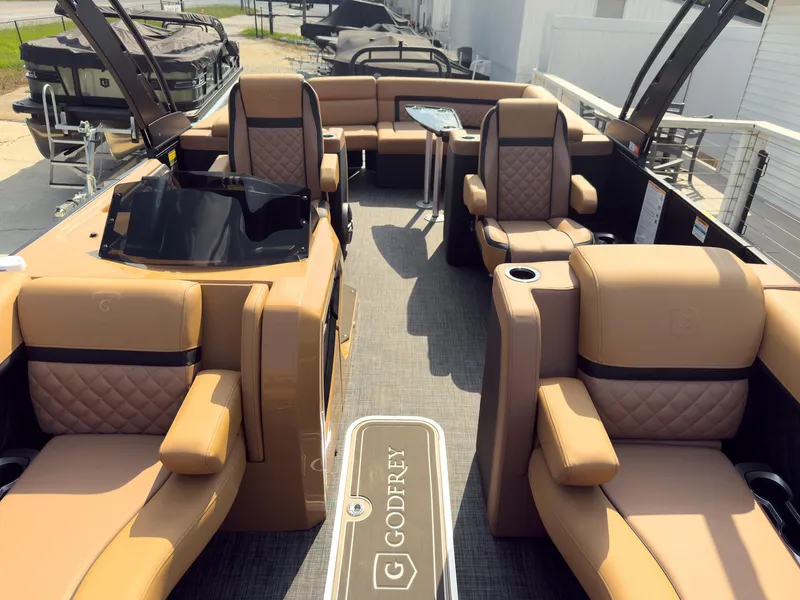 Slide: The Image of 2026 Godfrey Aquapatio 235 ULC Tritoon boat on trailer, black exterior, beige seating. - 30