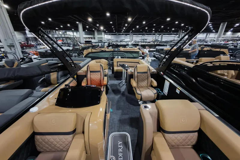 Slide: The Image of 2026 Godfrey Aquapatio 235 ULC Tritoon with luxurious seating at a boat show. - 4