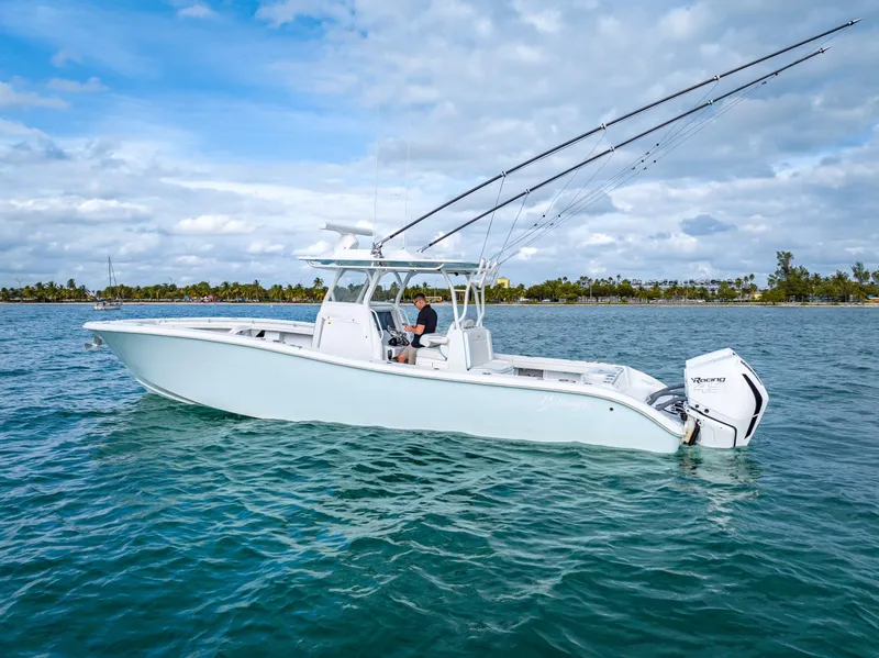 Slide: The Image of 2023 Yellowfin 36 boat on calm water, featuring fishing rods and outboard engines. - 11