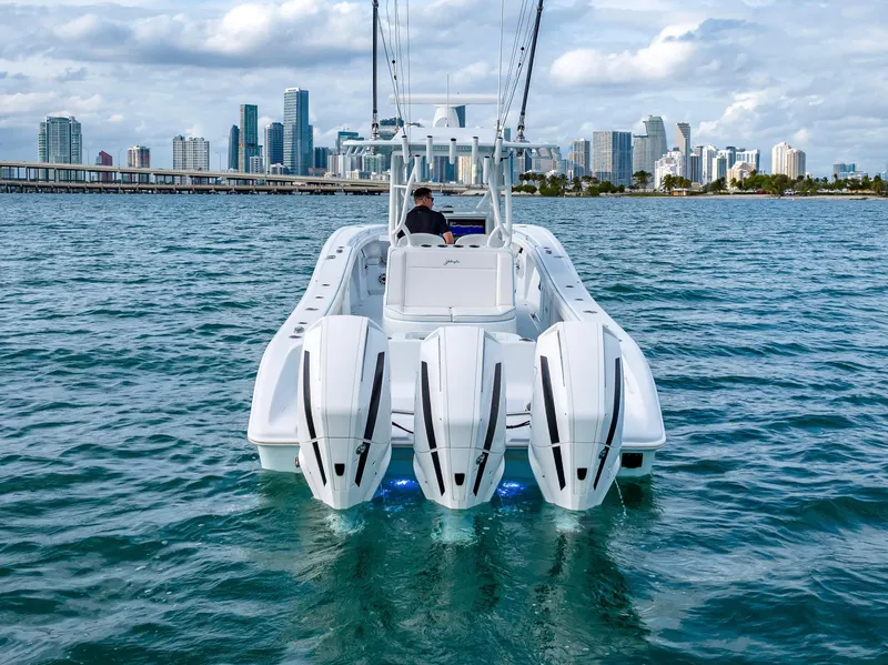 Slide: The Image of 2023 Yellowfin 36 boat with triple engines on water, city skyline in background. - 14