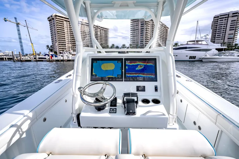 Slide: The Image of 2023 Yellowfin 36 boat dashboard with dual screens, docked in a marina. - 23