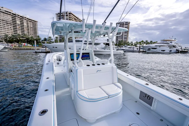 Slide: The Image of 2023 Yellowfin 36 boat docked at marina with luxury yachts and buildings in background. - 29