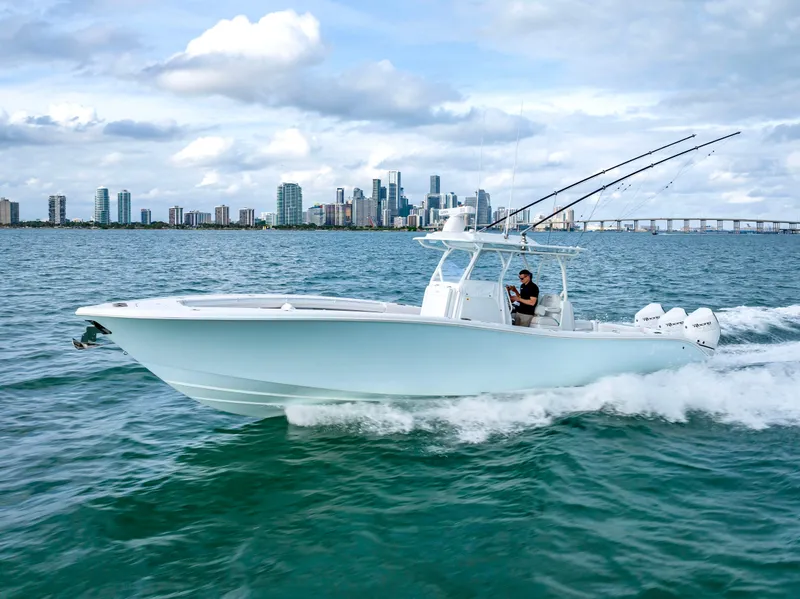 Slide: The Image of 2023 Yellowfin 36 boat cruising on ocean with city skyline in background. - 3