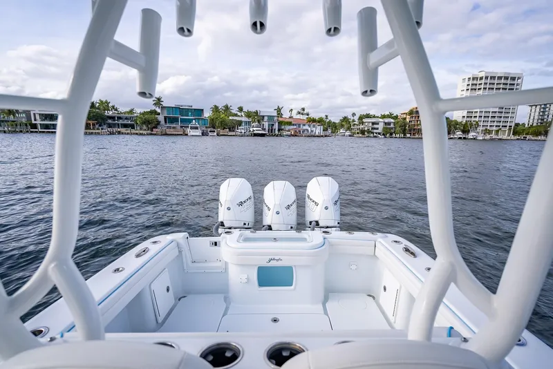 Slide: The Image of 2023 Yellowfin 36 boat with triple engines on a calm waterfront. - 38