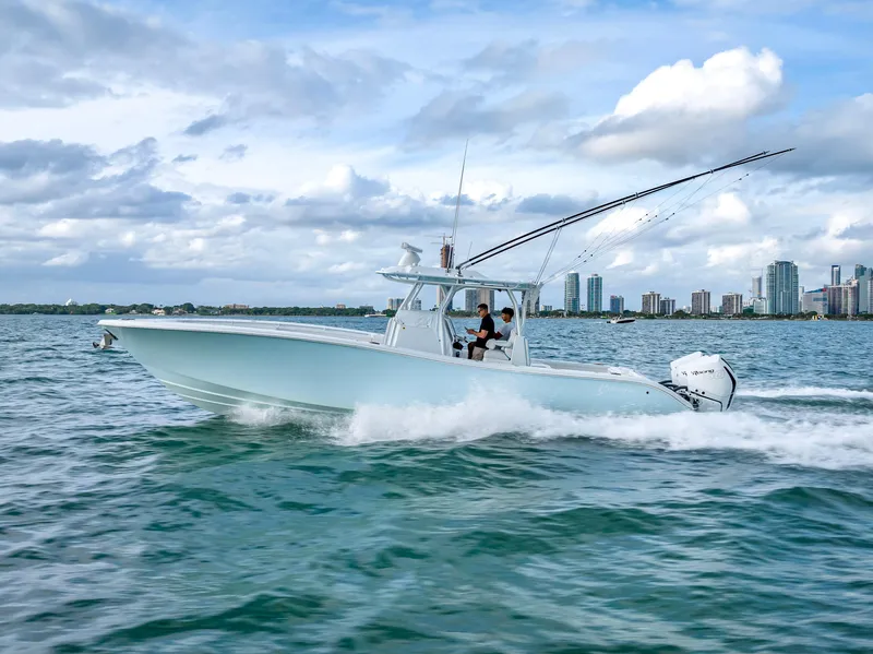 Slide: The Image of 2023 Yellowfin 36 boat cruising on water with city skyline in background. - 4