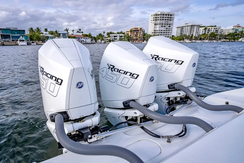 Slide: The Image of Triple Mercury Racing 450 outboard engines on a 2023 Yellowfin 36 boat, docked by waterfront buildings. - 42