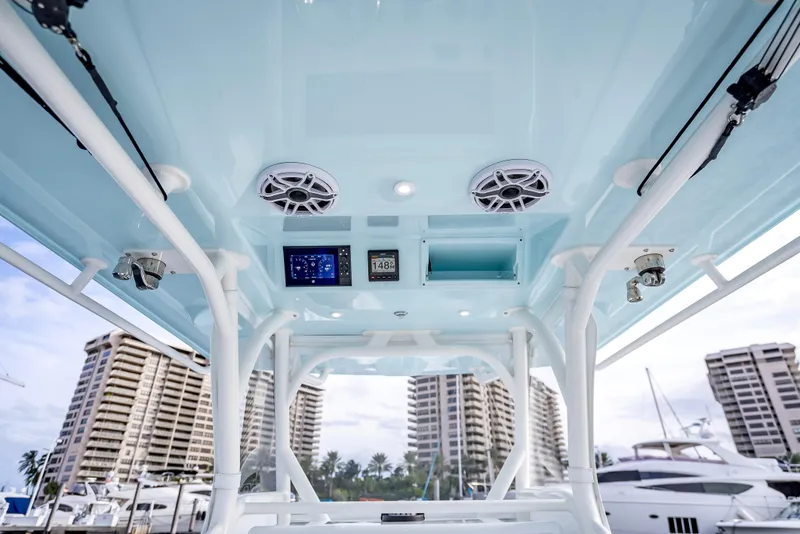 Slide: The Image of 2023 Yellowfin 36 boat interior with speakers and control panel, docked near high-rise buildings. - 44