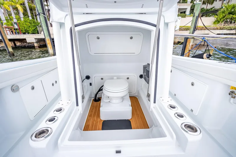 Slide: The Image of 2023 Yellowfin 36 boat interior with a compact marine toilet and storage compartments. - 46