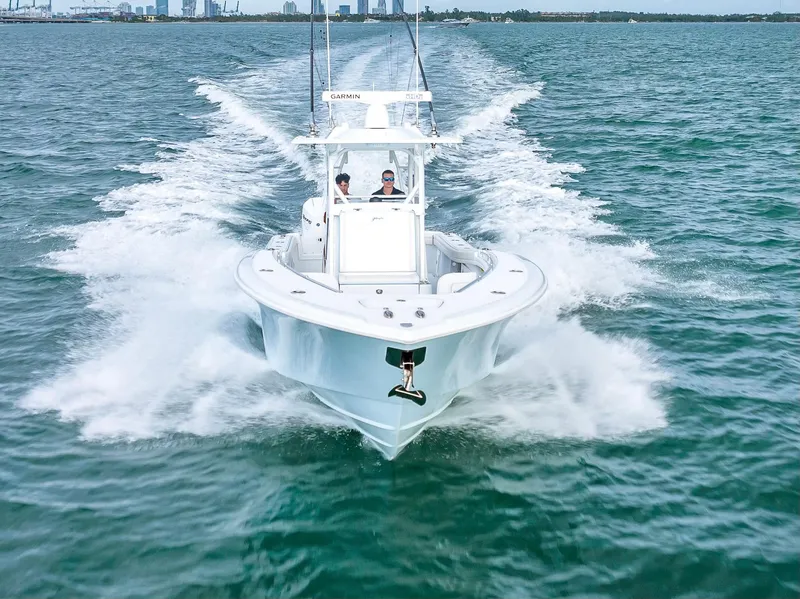 Slide: The Image of 2023 Yellowfin 36 boat cruising on open water, city skyline in background. - 5