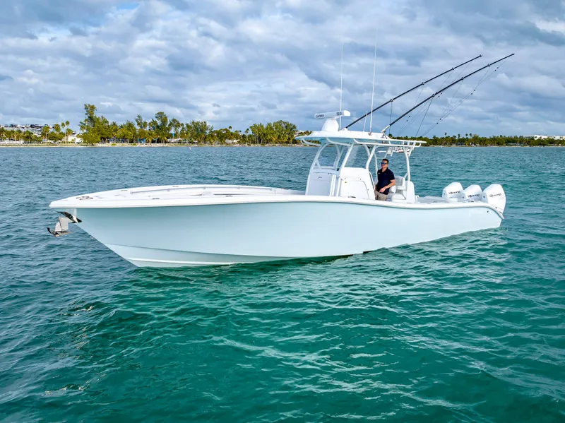 Slide: The Image of 2023 Yellowfin 36 boat on turquoise water, featuring sleek design and multiple fishing rods. - 8