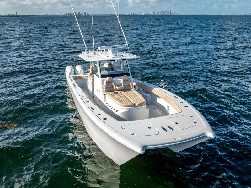 Slide: The Image of 2025 Freeman 35 boat cruising on open water with city skyline in background. - 2