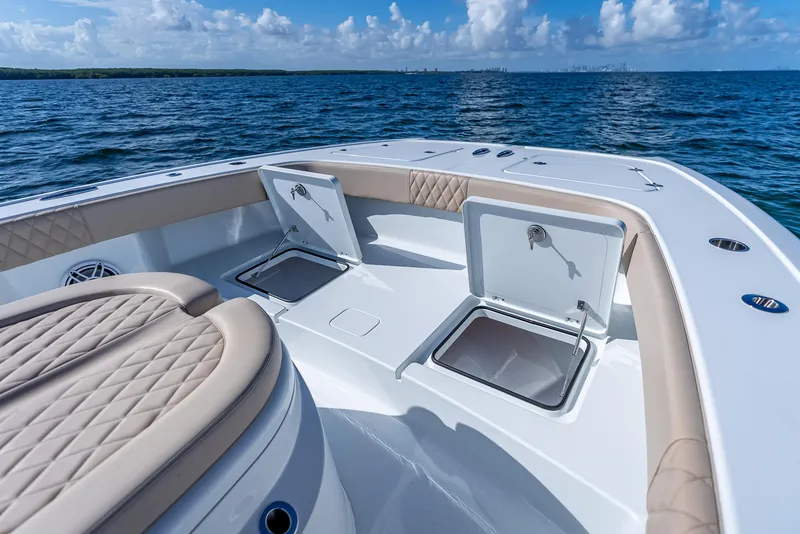 Slide: The Image of 2025 Freeman 35 boat deck with open storage compartments, ocean view, and quilted seating. - 45