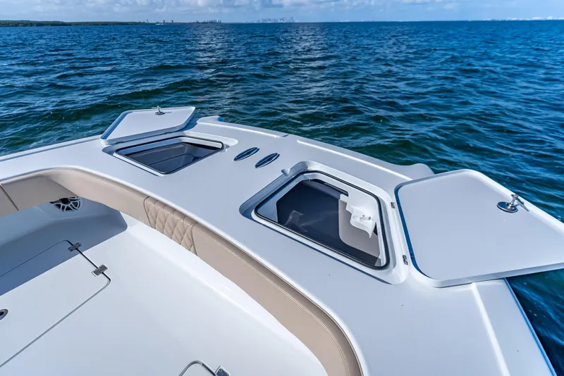 Slide: The Image of Freeman 35 boat deck with open storage compartments, 2025 model, on calm ocean waters. - 46