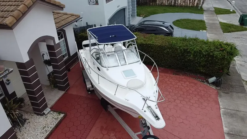 Slide: The Image of 2004 Cobia 250 Walk-Around boat on trailer in residential driveway. - 23