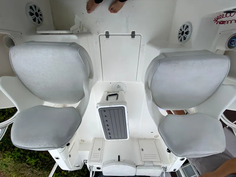 Slide: The Image of 2004 Cobia 250 Walk-Around boat interior with dual seats and control panel. - 24