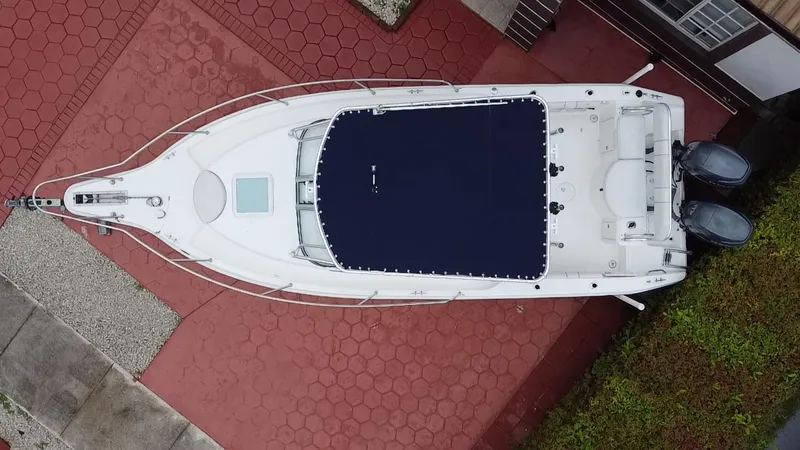 Slide: The Image of Overhead view of 2004 Cobia 250 Walk-Around boat on red paved surface. - 29