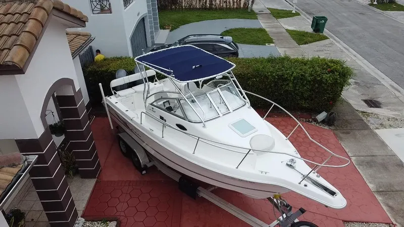 Slide: The Image of 2004 Cobia 250 Walk-Around boat on trailer in residential driveway. - 4