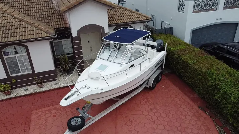 Slide: The Image of 2004 Cobia 250 Walk-Around boat on trailer in residential driveway. - 8