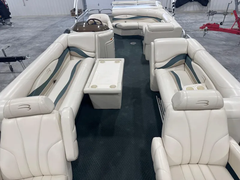 Slide: The Image of 2004 Bennington 2575 pontoon boat interior with white seating and table. - 11