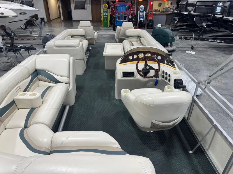Slide: The Image of 2004 Bennington 2575 pontoon boat interior with plush seating and steering console. - 7