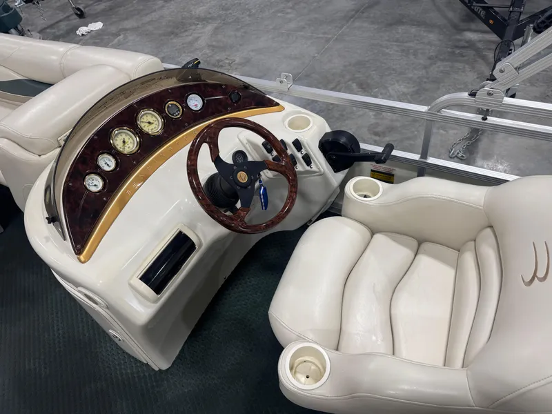 Slide: The Image of 2004 Bennington 2575 boat dashboard with gauges, steering wheel, and comfortable seating. - 8