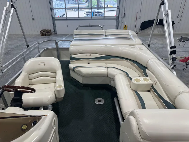 Slide: The Image of 2004 Bennington 2575 pontoon boat interior with white seating and steering wheel. - 9