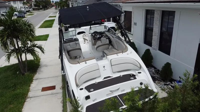 Slide: The Image of 2013 Yamaha Boats SX240 HO parked beside a house, featuring sleek design and spacious interior. - 25