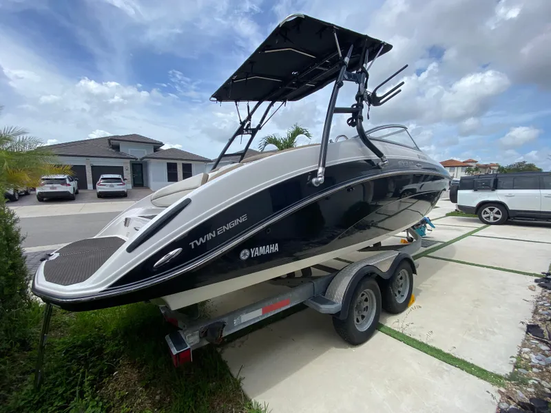 Slide: The Image of 2013 Yamaha Boats SX240 HO on trailer, parked in driveway under cloudy sky. - 27