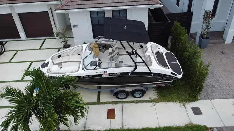 Slide: The Image of 2013 Yamaha SX240 HO boat on trailer parked in residential driveway. - 4