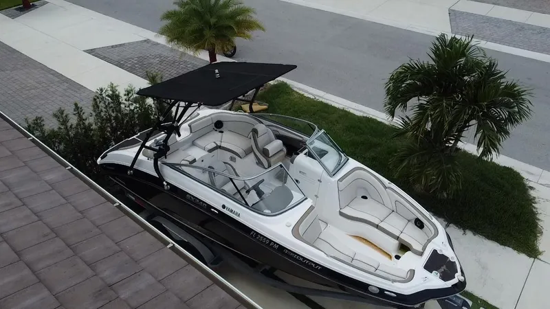 Slide: The Image of 2013 Yamaha SX240 HO boat with canopy, parked near palm trees. - 6