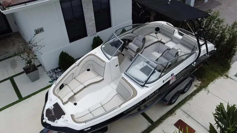 Slide: The Image of 2013 Yamaha Boats SX240 HO on trailer, parked beside a modern house. - 7