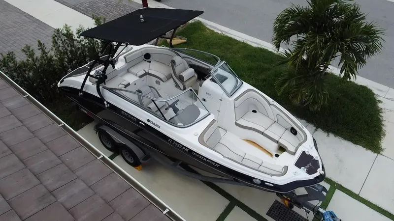 Slide: The Image of 2013 Yamaha Boats SX240 HO on trailer, parked near palm tree and driveway. - 8