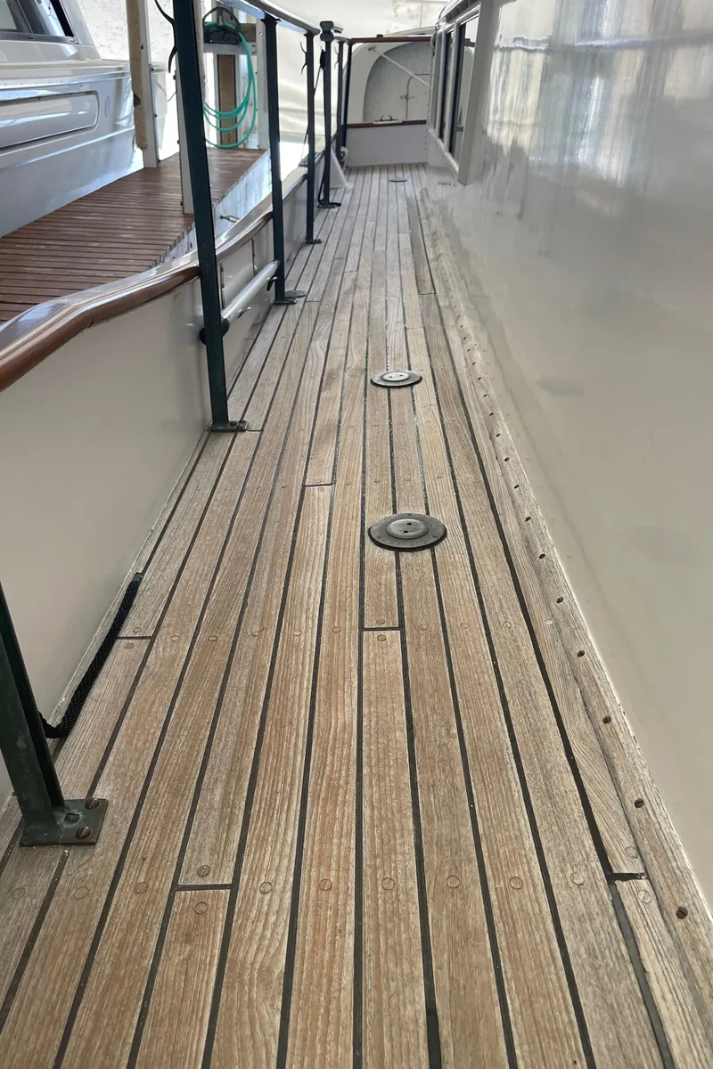 Slide: The Image of Wooden deck of a 1969 Grand Banks 36 Classic yacht, featuring sleek railings. - 10