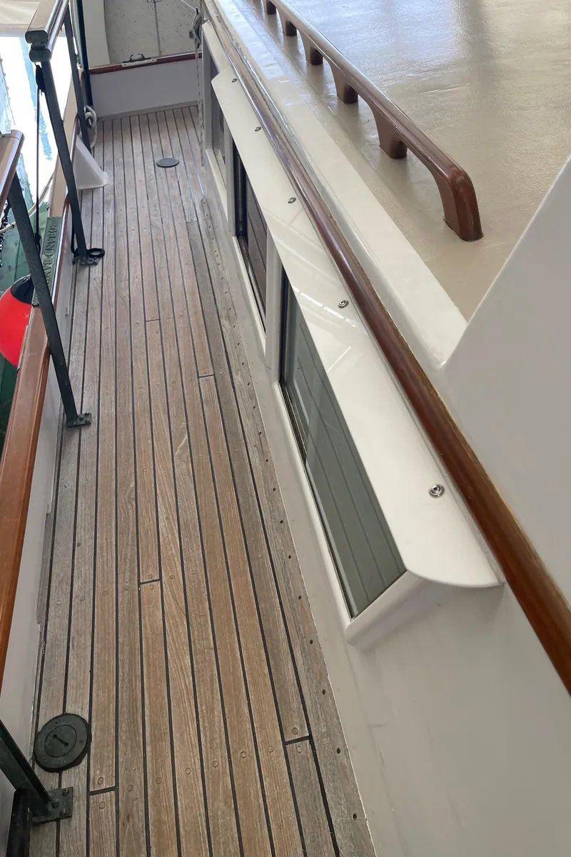 Slide: The Image of Side deck of a 1969 Grand Banks 36 Classic boat with wooden railings. - 12