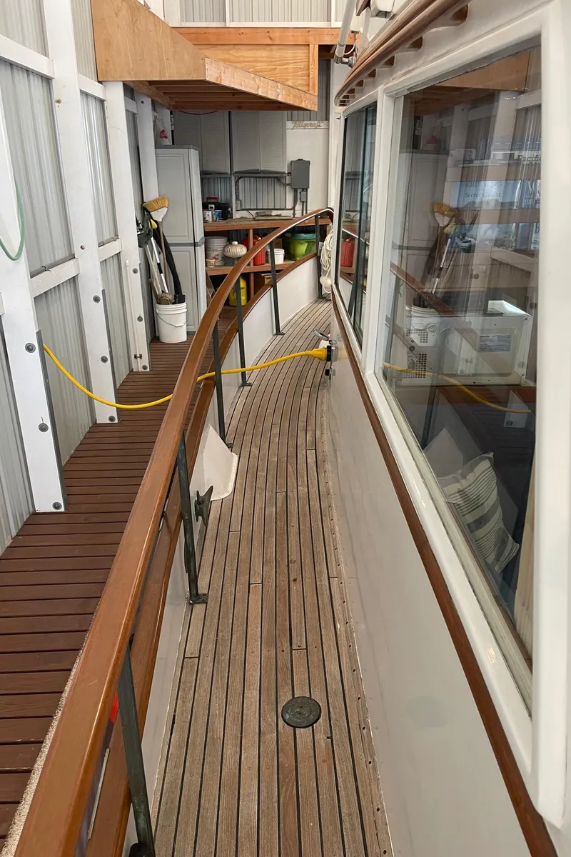 Slide: The Image of 1969 Grand Banks 36 Classic yacht with wooden deck and railing in a covered dock. - 14