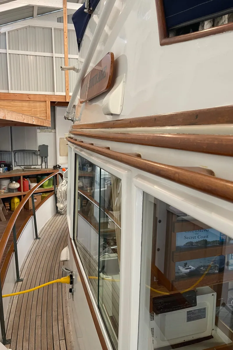 Slide: The Image of 1969 Grand Banks 36 Classic yacht in a marina, showcasing wooden deck and cabin details. - 15