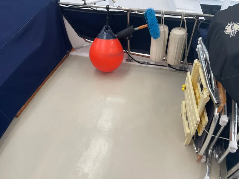 Slide: The Image of Deck of 1969 Grand Banks 36 Classic with fenders, brush, and folding chairs. - 21