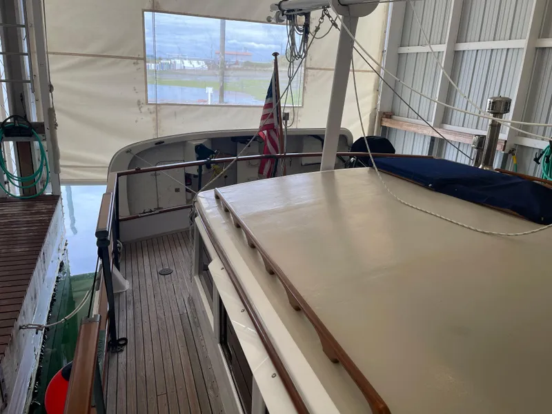 Slide: The Image of 1969 Grand Banks 36 Classic yacht in dock, featuring wooden deck and American flag. - 24