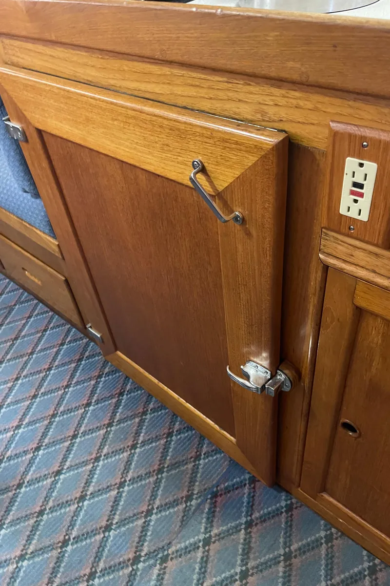 Slide: The Image of Wooden cabinetry on 1969 Grand Banks 36 Classic boat interior, featuring a plaid carpet. - 34