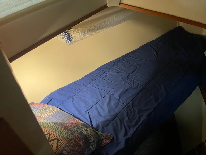 Slide: The Image of Cozy cabin bed in 1969 Grand Banks 36 Classic boat, with blue bedding and patterned pillow. - 39