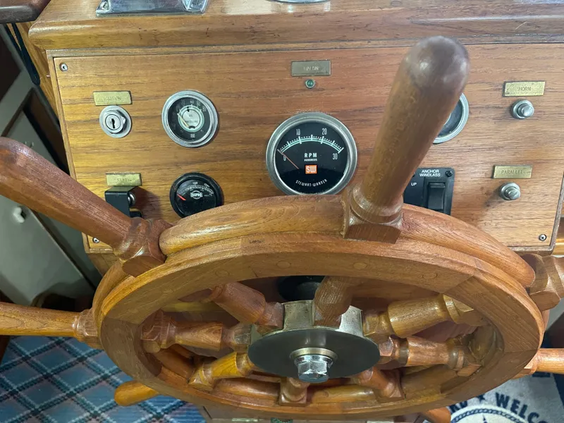 Slide: The Image of Wooden helm of a 1969 Grand Banks 36 Classic boat with gauges and controls. - 41