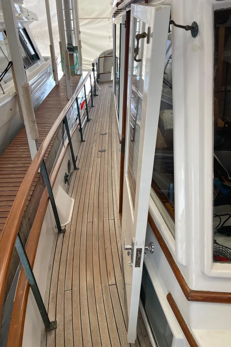 Slide: The Image of Side deck view of a 1969 Grand Banks 36 Classic boat with wooden railings. - 9