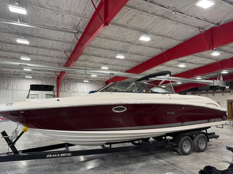 Slide: The Image of 2006 Sea Ray 290 SLX boat on trailer in indoor storage facility. - 2