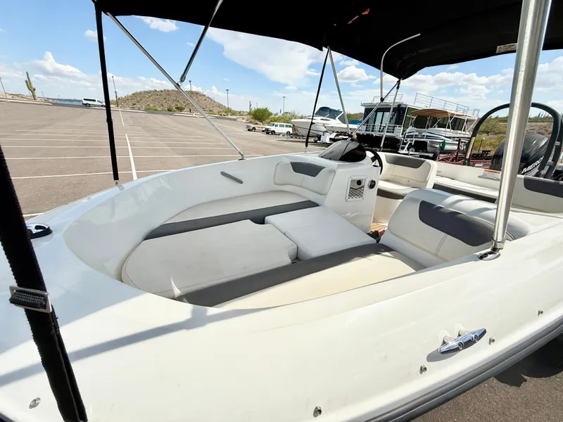Slide: The Image of 2017 Bayliner Element E16 boat interior with seating, parked outdoors under a clear sky. - 10