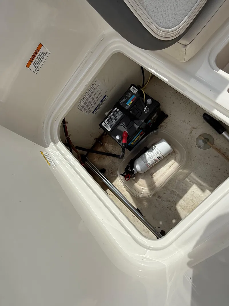Slide: The Image of 2017 Bayliner Element E16 boat compartment with battery and fire extinguisher. - 16