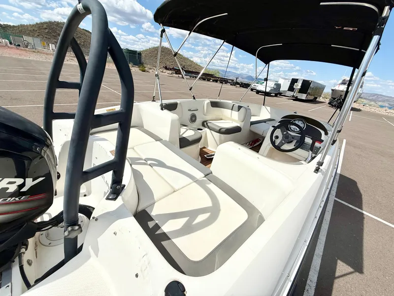 Slide: The Image of 2017 Bayliner Element E16 boat interior with seating and steering wheel, parked outdoors. - 7