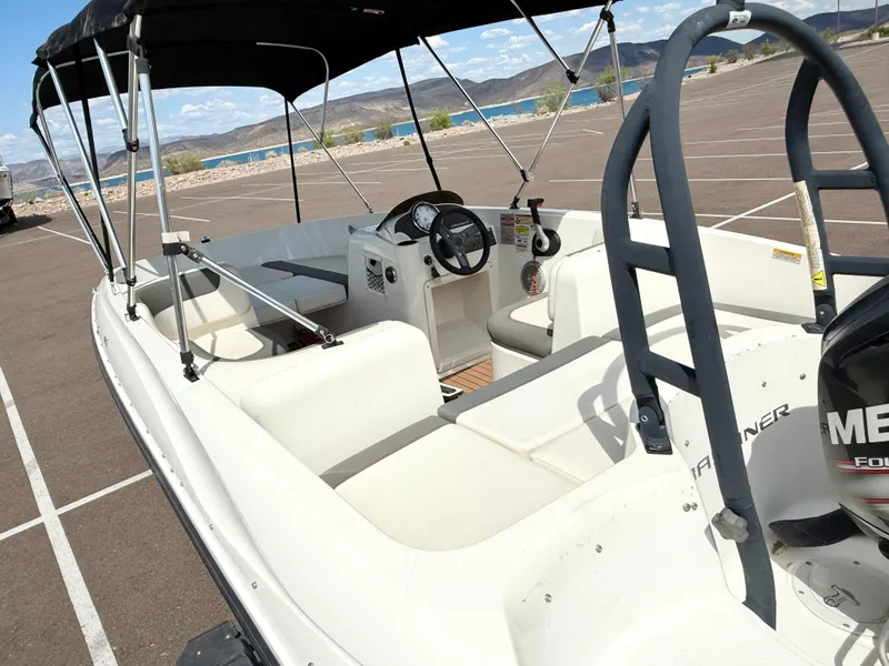 Slide: The Image of 2017 Bayliner Element E16 boat with canopy, parked in a scenic lakeside area. - 8